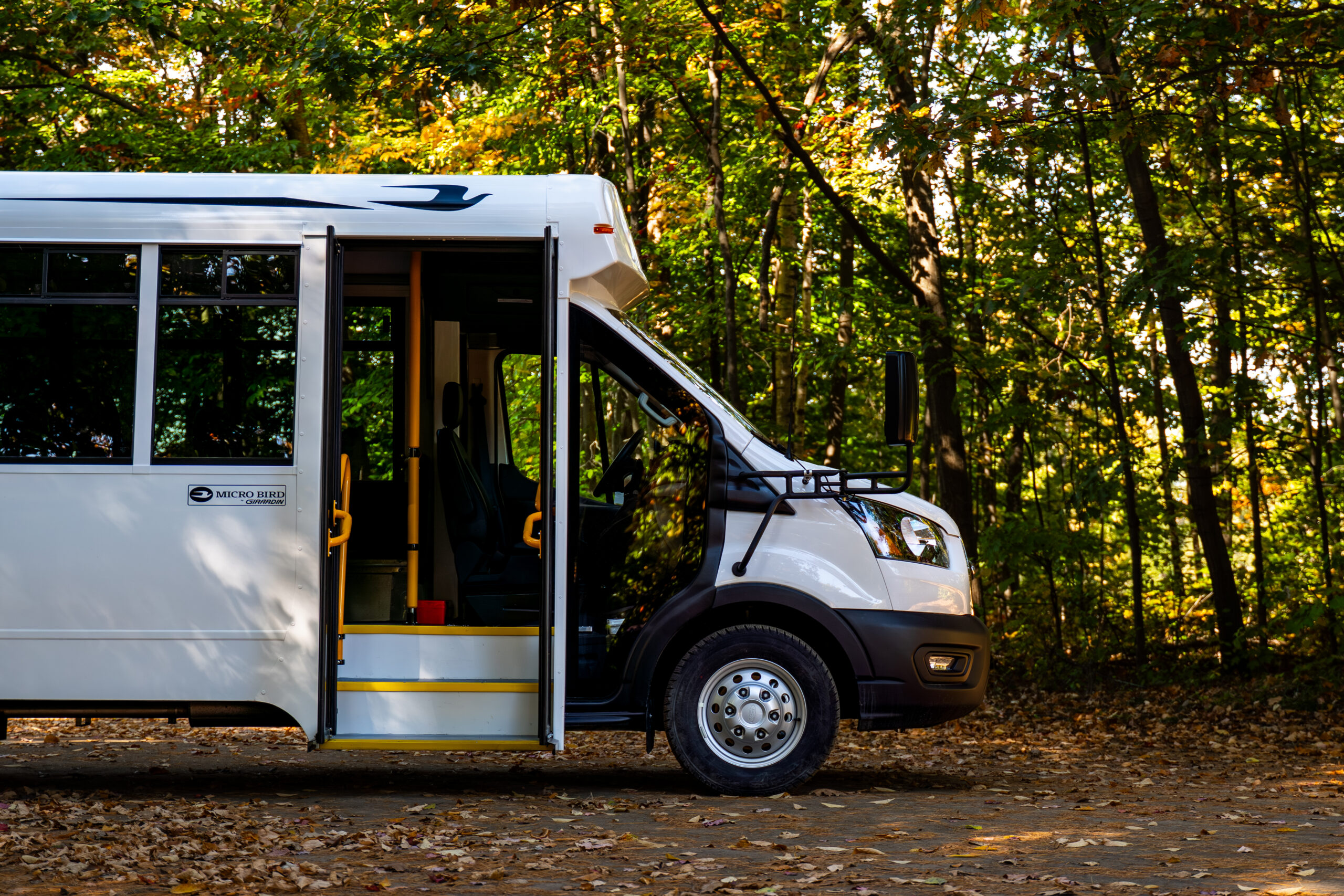 Micro Bird CT-Series commercial bus with open door in a fall setting